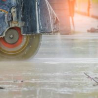 Concrete,road,cutters,with,worker,when,raining,over,the,sand